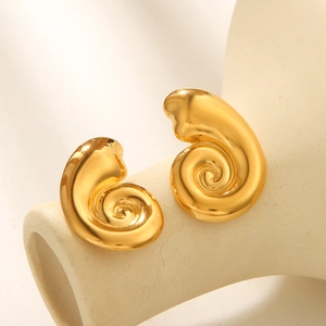 Polished gold conch spiral stud earrings in stainless steel on a minimalist display