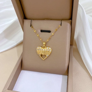 Gold heart pendant necklace engraved with MAMA and crystals in a luxury jewelry box