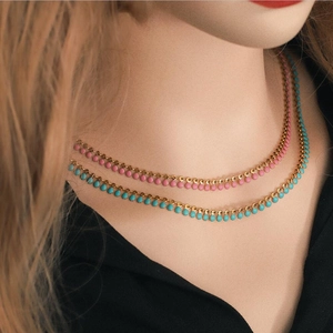 Handmade stainless steel colorful enamel layered necklaces worn on a model's neck