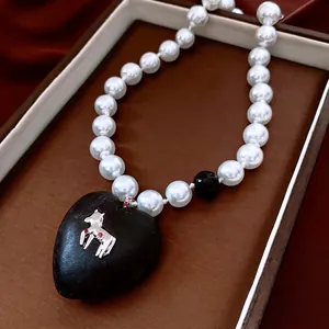 Vintage pearl necklace with large black heart pendant and silver horse relief detail