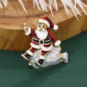 Charming Santa Claus enamel brooch with gold glitter detail on a green festive background