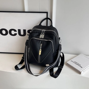 Close-up of black litchi grain leather backpack with V-stitch and woven strap