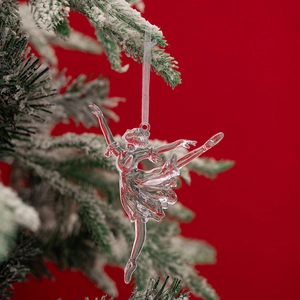Close-up of clear acrylic ballet dancer ornament with white ribbon on a Christmas tree
