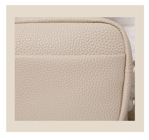 Close-up of beige PU leather texture and precise stitching on the square crossbody bag