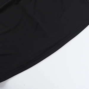 Détail de l'ourlet à double surpiqûre sur robe noire à manches longues en maille lisse