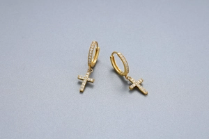 Close-up of gold S925 sterling silver cross earrings with sparkling cubic zirconia stones