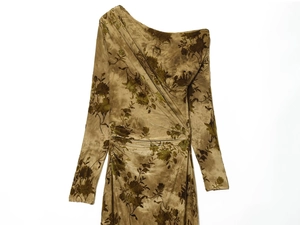 Detail of olive green velvet fabric texture and ruched draping on long sleeve dress