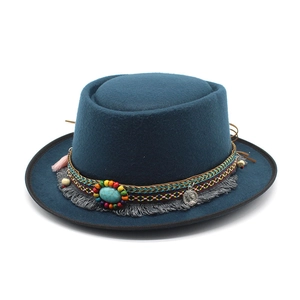Detail of wool fedora with ethnic woven band, turquoise stone, and vintage coin pendant