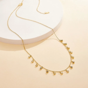 Detail of gold S925 silver necklace featuring delicate white zircon tassel pendants