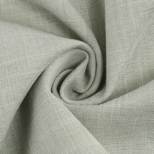 Gros plan du tissu textile vert sauge montrant la texture lisse et le drapé doux