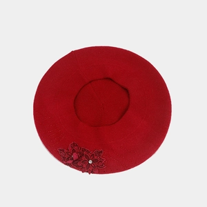 Detailed top view of red knit beret featuring a 3D floral applique and sparkling rhinestones