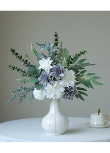 Macro view of white and grey silk dahlia flowers with green eucalyptus in a ceramic vase