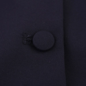 Close-up of contrast-colored fabric button on navy sailor collar sleeveless blouse