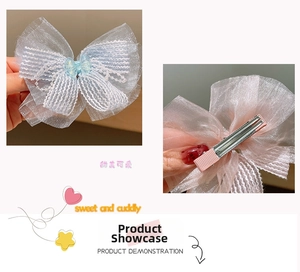 Detail of light blue mesh bow hair clip with pearl center and metal duckbill buckle