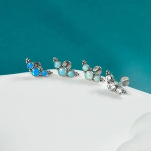 Detail view of G23 titanium labret studs with opal and cubic zirconia floral cluster