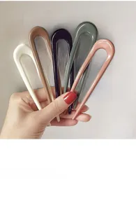 Close-up of five colorful U-shaped minimalist hair forks in matte resin finish