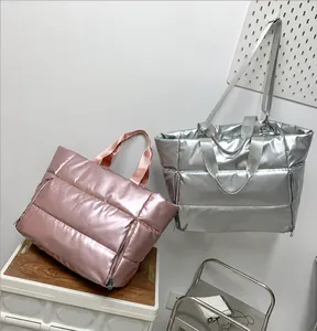 Detail of rose gold and silver quilted down tote bags with metallic glossy finish