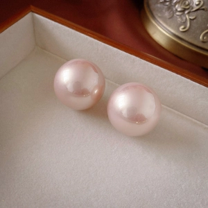 Detail of two round pink faux pearls with pearlescent luster in a velvet jewelry box