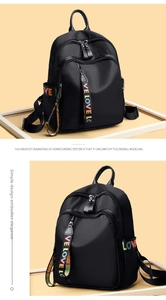 Close-up of black nylon backpack featuring colorful LOVE letter printed straps and zipper