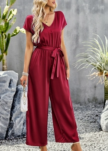 Detail of burgundy V-neck short sleeve jumpsuit with waist belt and silky texture