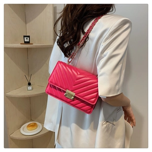 Detail of rose pink chevron quilted bag with gold metal clasp and chain strap
