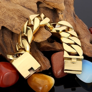 Chunky 26mm golden stainless steel Cuban link bracelet for men on natural wood