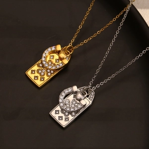 Detail view of gold and silver horseshoe pendants with shiny rhinestones on a dark tray
