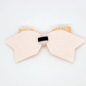 Detail of pink fabric bow with gold glitter back and black elastic band on white background