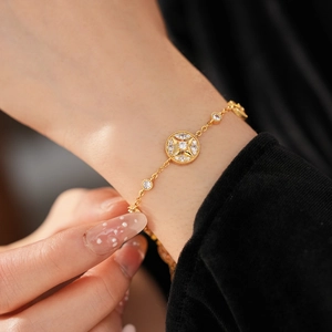 Detailed view of 18K gold plated bracelet featuring a starburst medallion and zircon