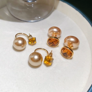 Detailed macro view of 18K gold plated earrings with vintage amber crystals and pearls