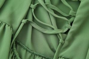 Détail du laçage au dos sur robe en mousseline verte avec finitions de couture