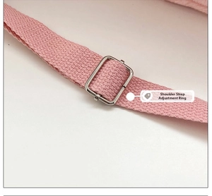 Detail view of pink woven shoulder strap with silver adjustable metal buckle on cat bag