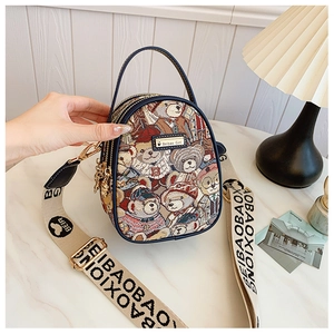 Detail showing teddy bear pattern woven fabric handbag with navy trim and gold hardware