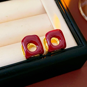 Macro shot of French vintage square enamel hoop earrings in gold with red finish