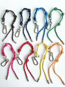 Detail van acht kleurrijke gevlochten nylon touwsleutelhangers met metalen haken