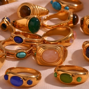 Gold-plated stainless steel rings with colorful natural stones on soft fabric