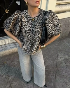 Detail of leopard print puff sleeve top styled with light grey wide-leg denim jeans