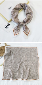 Macro shot of leopard print square scarf with striped border on a white textured backdrop