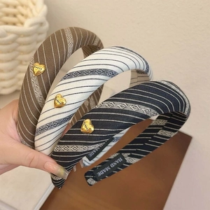 Striped sponge headbands in brown, white, and blue with heart-shaped golden details