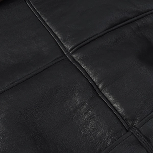 Close-up of premium black leather texture with detailed cross-stitch craftsmanship