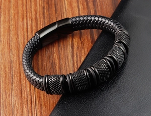 Macro detail of hand-woven black leather bracelet with textured magnetic clasp