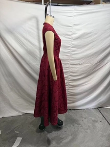 Détail d'une robe longue trapèze rouge foncé avec motif élégant en jacquard de roses