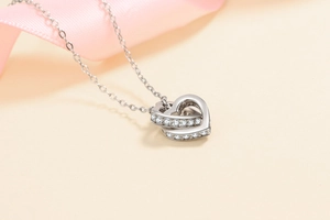 Détail du collier en argent S925 avec cœurs entrelacés et accents de pierre moissanite