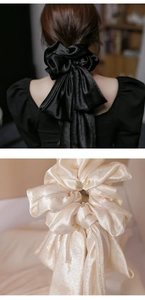 Detail of satin bow hair tie with pearlescent finish in black and champagne colors