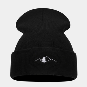 Close-up of mountain peak embroidery on thick black knitted winter beanie hat