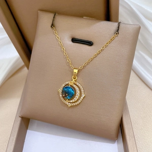 Gros plan d'un collier doré en titane avec pendentif planète bleue serti de zircons
