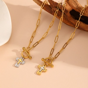 Collier croix martelée bicolore avec chaîne trombone et fermoir OT sur bois