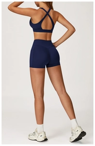 Detail of navy blue high-waist fitness shorts with a side pocket and cross-back sports bra