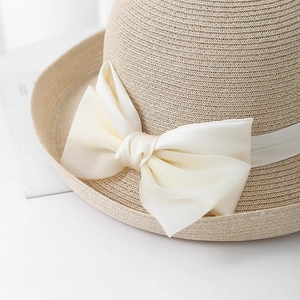 Detailopname van de elegante witte strik van lint op een Franse stijl strooien zonnehoed