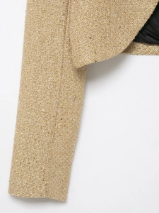 Detailed macro view of champagne gold tweed fabric with metallic threads and sequins